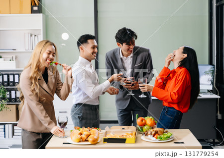 Lively office party with coworkers celebrating, enjoying pizza and drinks, and fostering team spirit 131779254