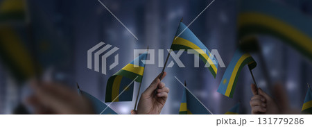 Rwanda flags in their hands on a blurred urban background Rwanda flags in their hands on a blurred urban background 131779286