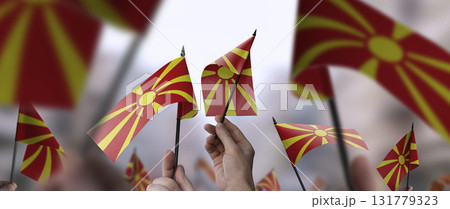 Macedonia flags in their hands on a blurred urban background 131779323