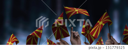 Macedonia flags in their hands on a blurred urban background 131779325