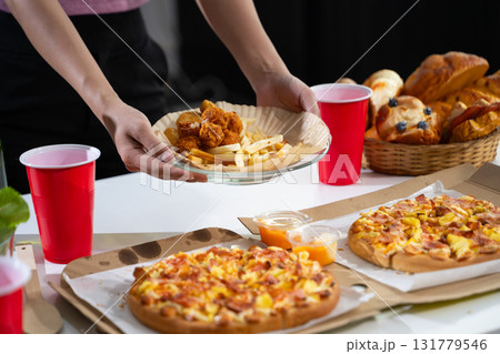 Women's hands holding breakfast, croissants, bakery, pizza on the table, preparing a party. Women's hands holding breakfast, croissants, bakery, pizza on the table, preparing a party. 131779546