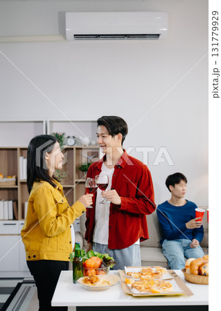 Group of Young Asian friend having, enjoy evening party together at home. Attractive young man and woman having fun, eating food, celebrate at home 131779929