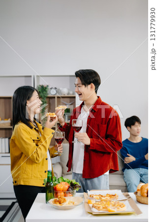 Group of Young Asian friend having, enjoy evening party together at home. Attractive young man and woman having fun, eating food, celebrate at home 131779930
