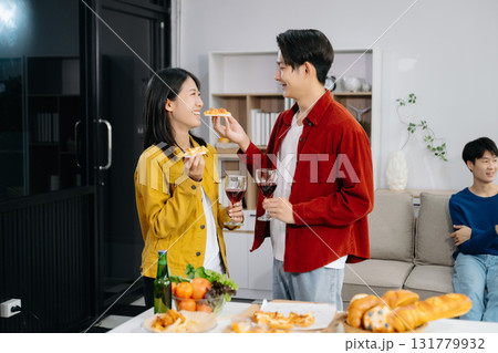 Group of Young Asian friend having, enjoy evening party together at home. Attractive young man and woman having fun, eating food, celebrate at home 131779932