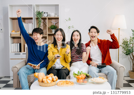 Young Asian friend having, enjoy evening party together at home. Attractive young man and woman having fun, eating foo Young Asian friend having, enjoy evening party together at home. Attractive young man and woman having fun, eating foo 131779953