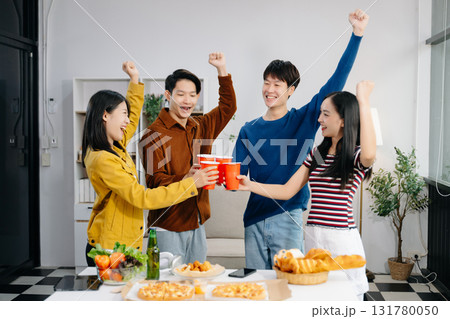 Group of Young Asian friend having, enjoy evening party together at home. Attractive young man and woman having fun, eating food, celebrate at home Group of Young Asian friend having, enjoy evening party together at home. Attractive young man and woman having fun, eating food, celebrate at home 131780050