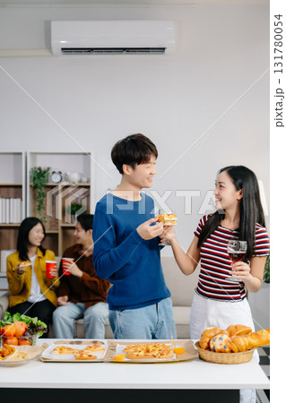 Group of Young Asian friend having, enjoy evening party together at home. Attractive young man and woman having fun, eating food, celebrate at home 131780054
