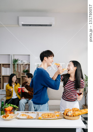 Group of Young Asian friend having, enjoy evening party together at home. Attractive young man and woman having fun, eating food, celebrate at home 131780057