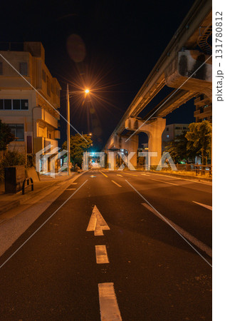 オレンジ色の街灯が明るい深夜のモノレールのレールと道路 131780812