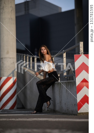 Woman posing on the road wearing fashionable clothes 131781595