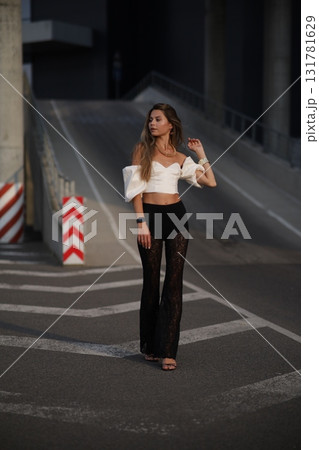 Woman posing on the road wearing fashionable clothes Woman posing on the road wearing fashionable clothes 131781629