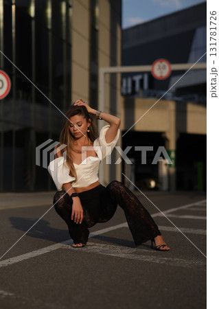 Woman posing on the road wearing fashionable clothes 131781726
