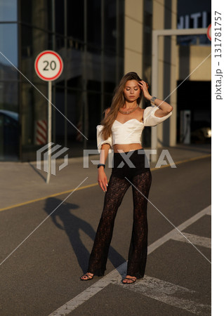 Woman posing on the road wearing fashionable clothes Woman posing on the road wearing fashionable clothes 131781757