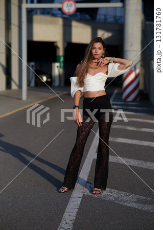 Woman posing on the road wearing fashionable clothes Woman posing on the road wearing fashionable clothes 131781760