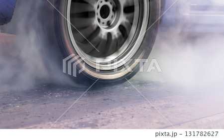 Smoke on wheel of drag racing car at starting line. 131782627