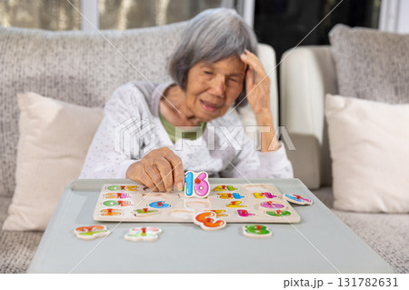 Asian Senior Woman With Dementia is Confuse a Number Puzzle Game. 131782631