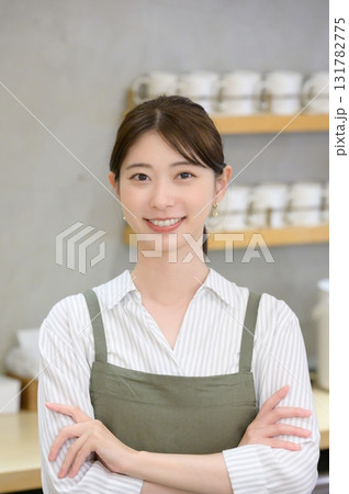カメラ目線で腕組みをするカフェ店員の女性 131782775