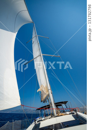 White sails filled with wind, seen from the bow of a sailing yacht near Croatia. Freedom, clean energy, adventure and mindful travel on the open sea. White sails filled with wind, seen from the bow of a sailing yacht near Croatia. Freedom, clean energy, adventure and mindful travel on the open sea. 131782798
