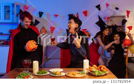 Dinner and group of people celebrating together at Halloween party. Dinner and group of people celebrating together at Halloween party. 131782954
