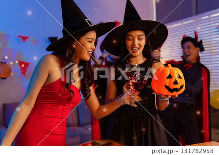 Dinner and group of people celebrating together at Halloween party. 131782958