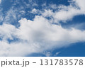 White fluffy clouds floating peacefully in the bright blue sky 131783578