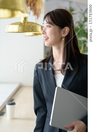 パソコンを持って立つ女性 131783600