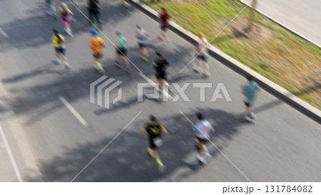 Individuals are participating in a marathon through the streets of a metropolitan area, their figures indistinct as they sprint towards victory. Individuals are participating in a marathon through the streets of a metropolitan area, their figures indistinct as they sprint towards victory. 131784082