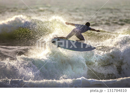 A surfer rode the wave in a jump, splashing 131784810