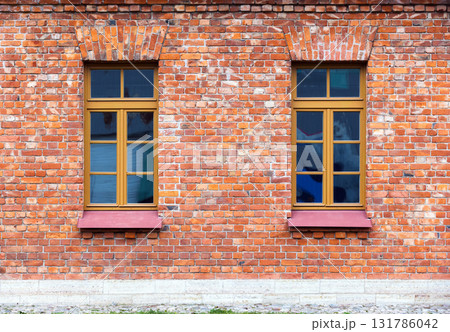 Two windows with wooden frames set in a rustic red brick wall. Photo texture Two windows with wooden frames set in a rustic red brick wall. Photo texture 131786042