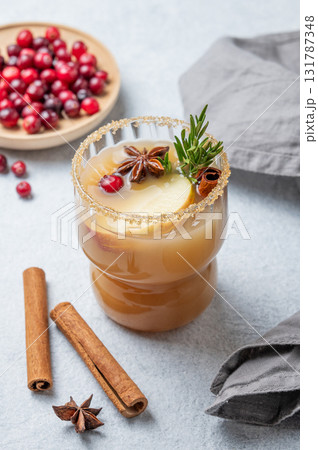 Hot apple cider with cinnamon, anise, brown sugar and rosemary in a glass on a light background 131787348