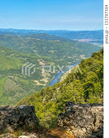 Canyon river meandering among green forested mountains; nature landscape photography under blue sky 131787384