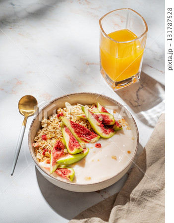 Natural yogurt with granola, figs and honey in a bowl on a marble background Natural yogurt with granola, figs and honey in a bowl on a marble background 131787528