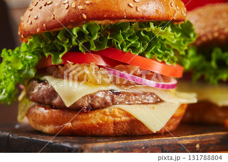 Appetizing homemade burger with beef, cheese and onion marmalade close-up. Fast food concept, american food Appetizing homemade burger with beef, cheese and onion marmalade close-up. Fast food concept, american food 131788804