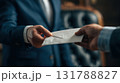 Businessman Handing Envelope in Office Setting 131788827