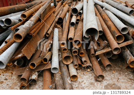 Pile of Rusty Metal Pipes in Scrap Yard 131789324