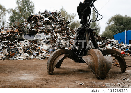 Industrial Scrap Yard with Hydraulic Grab Machine at Work Industrial Scrap Yard with Hydraulic Grab Machine at Work 131789333