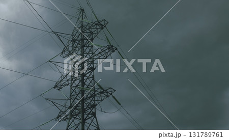 A Dramatic High Voltage Power Line Silhouetted Against the Foreboding Dark Sky Background A Dramatic High Voltage Power Line Silhouetted Against the Foreboding Dark Sky Background 131789761