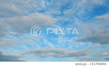 A Beautiful Blue Sky adorned with Fluffy White Clouds that Float Gracefully Above 131789848