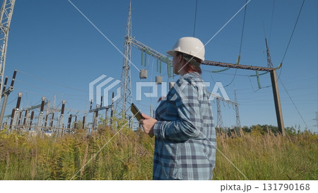 Experienced Engineer Analyzing Complex Data in a Power Substation Working Environment Experienced Engineer Analyzing Complex Data in a Power Substation Working Environment 131790168
