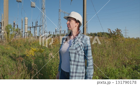 An engineer is inspecting electrical equipment while working outdoors in a professional capacity An engineer is inspecting electrical equipment while working outdoors in a professional capacity 131790178