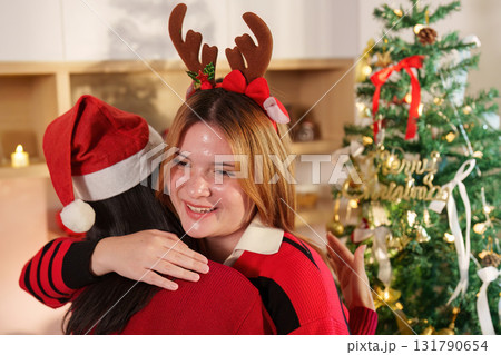 Festive Hug. Two women celebrating Christmas with joy and holiday spirit. Festive Hug. Two women celebrating Christmas with joy and holiday spirit. 131790654