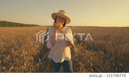 A Joyful Woman in a Wheat Field at Sunset, Embracing the Beauty of Nature and Life 131790778