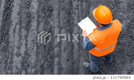 Aerial view of engineer inspecting construction site with clipboard Aerial view of engineer inspecting construction site with clipboard 131790964