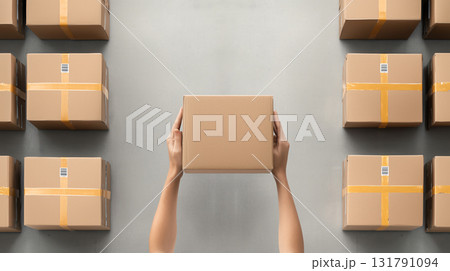 Efficient hands lifting box in warehouse filled with packages Efficient hands lifting box in warehouse filled with packages 131791094