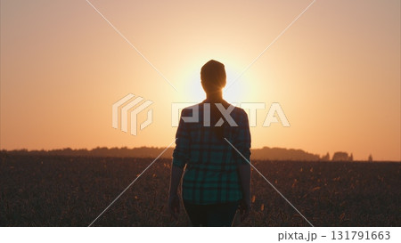 A stunning sunset silhouette against a serene landscape, painting the sky with colors A stunning sunset silhouette against a serene landscape, painting the sky with colors 131791663