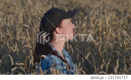 A Contemplative Woman in a Wheat Field Where She is Capturing the Beauty of Nature 131791717