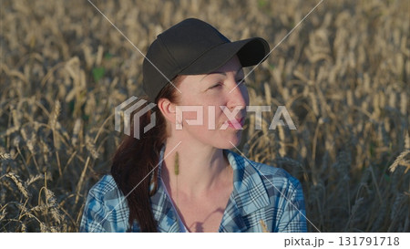 A woman stands in a wheat field, embracing the beauty of nature and her connection to it 131791718