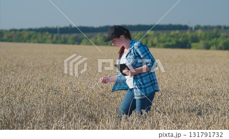 A young woman is seen using a tablet while in a picturesque field setting outdoors A young woman is seen using a tablet while in a picturesque field setting outdoors 131791732