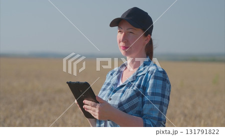 A Female Farmer Engaged in Analyzing Data Right in the Field of Agriculture and Nature A Female Farmer Engaged in Analyzing Data Right in the Field of Agriculture and Nature 131791822