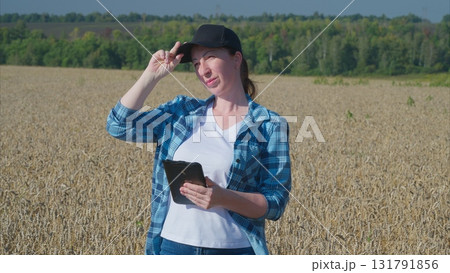 A farmer utilizing a tablet in the field for enhancing precision agriculture strategies 131791856